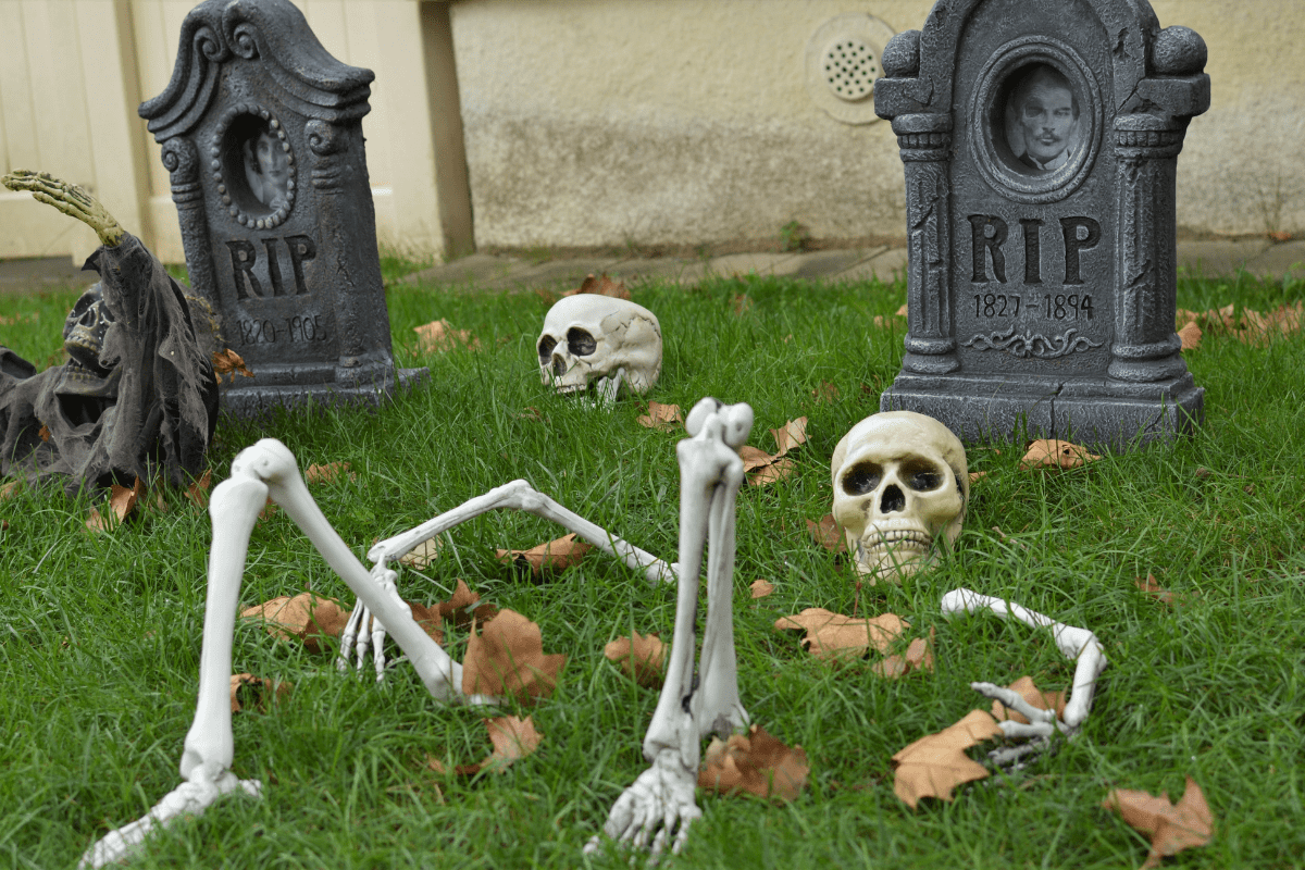 Plastic skeleton with tombstones in the grass