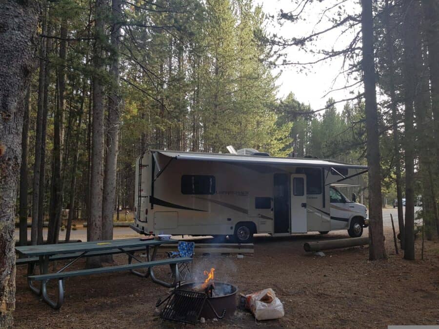 RV in the woods with awning out.