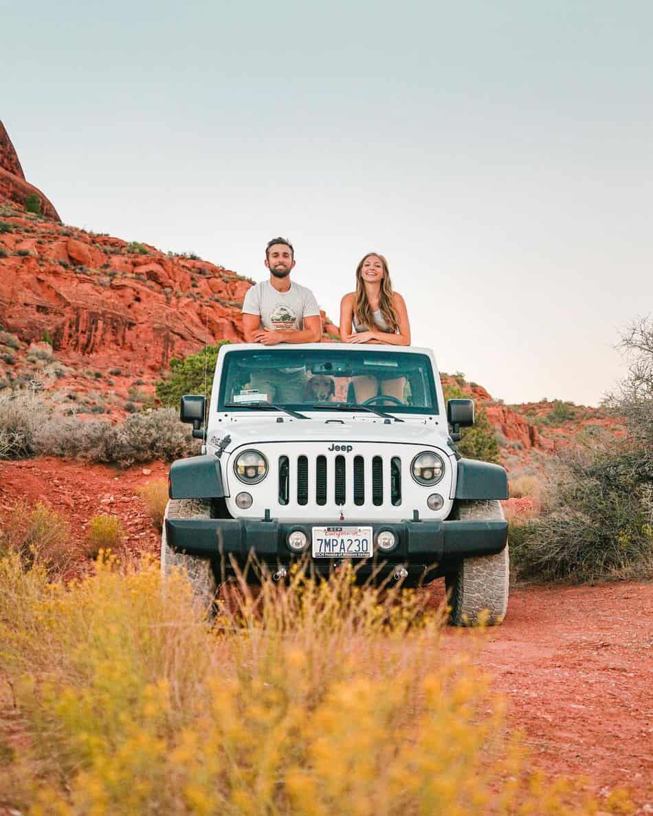Young couple, Emily and Cody, sitting through the top of a Jeep