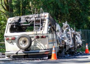 Mangled RV with two pylons by the side of the road