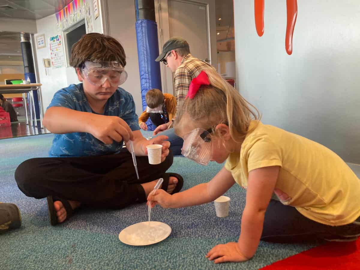 Roadschool kids doing a science experiment t on a cruise ship