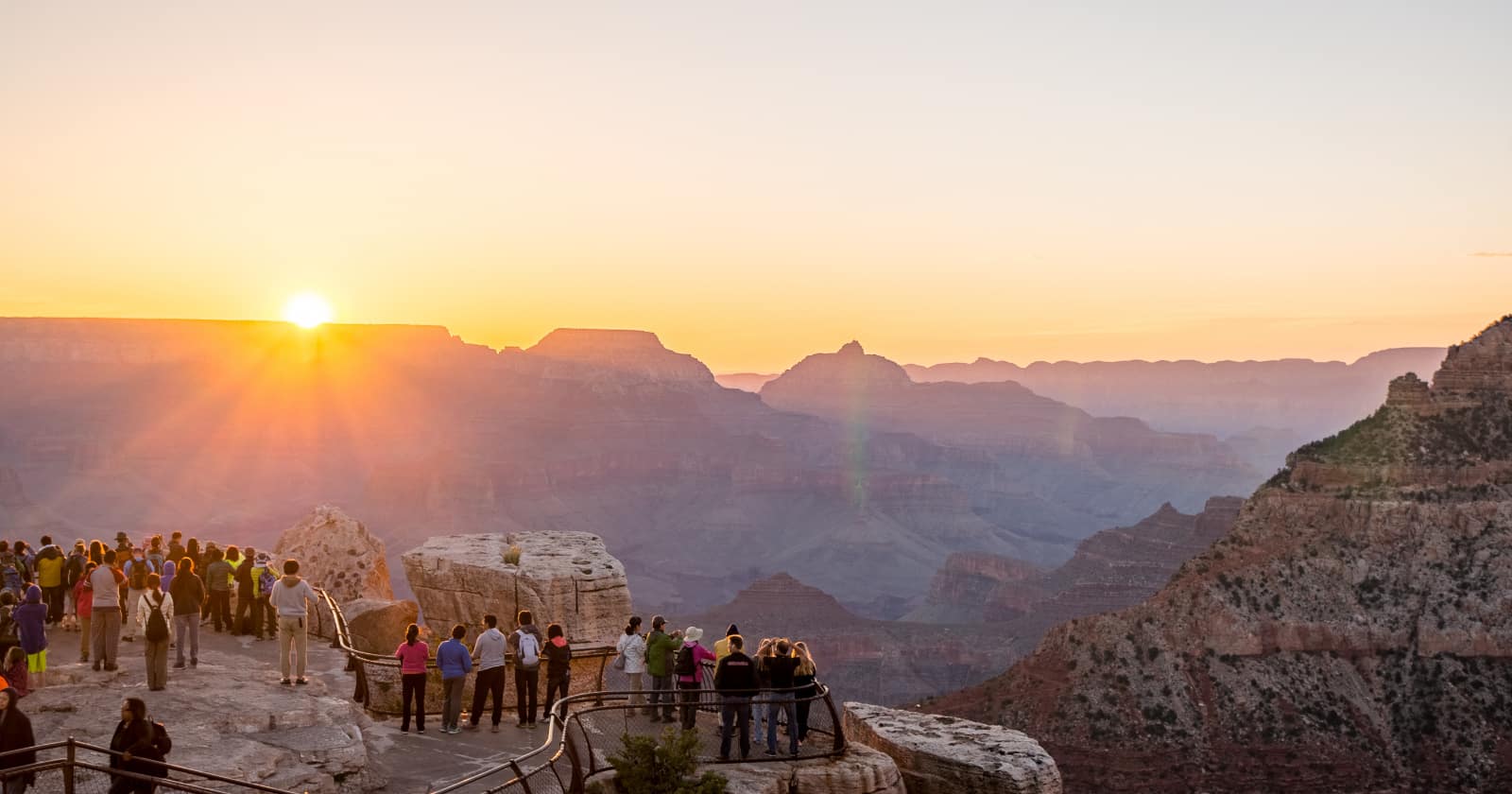crowds gathering to take photo of Sunrise from Mather Point at Grand Canyon National Park, on our list of worst national parks for crowds