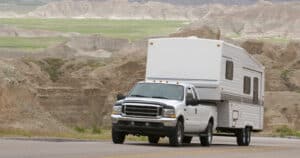 RV pick-up truck and fifth wheel utilizing fifth wheel gooseneck adapter climbing scenic mountain road in the Badlands