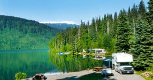 Free camping in Canada can look like these RVs camping by the beautiful mountain lake