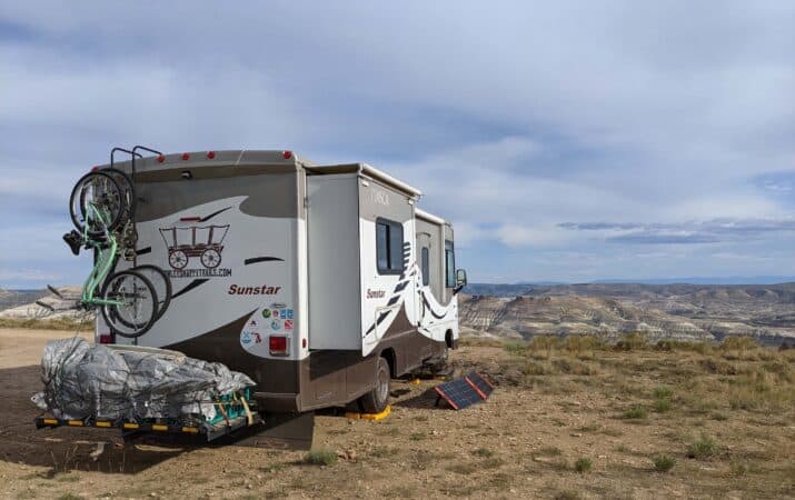 Motorhome parked overlooking a desert valley while Boondocking in Wyoming.