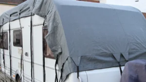A travel trailer with a tarp on top.