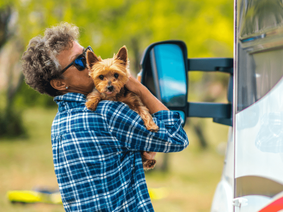 A woman holds her dog outside of her RV rental. 