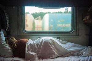 Woman lying on RV mattress with a big window in the background