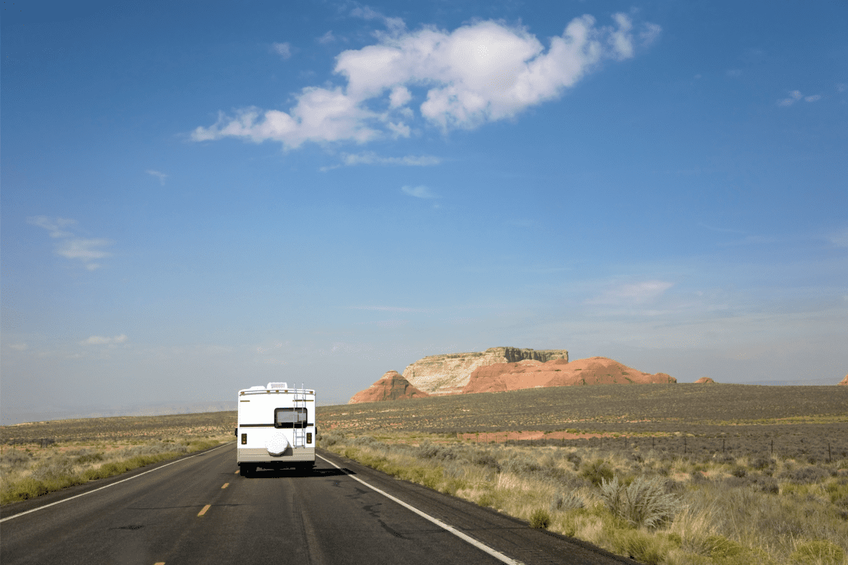 An RV driving down a rural desert highway