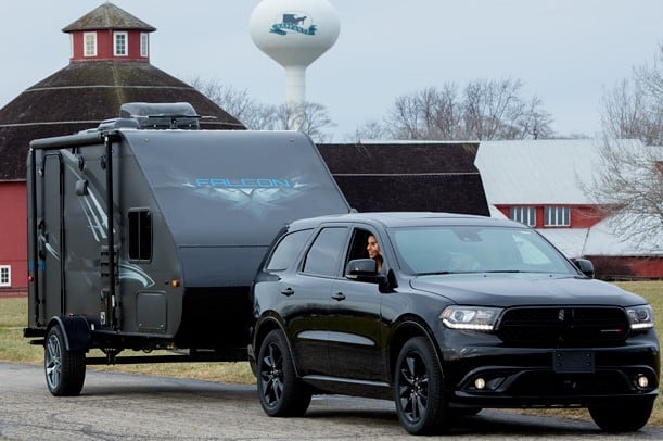 Small SUV towing a travel trailer.