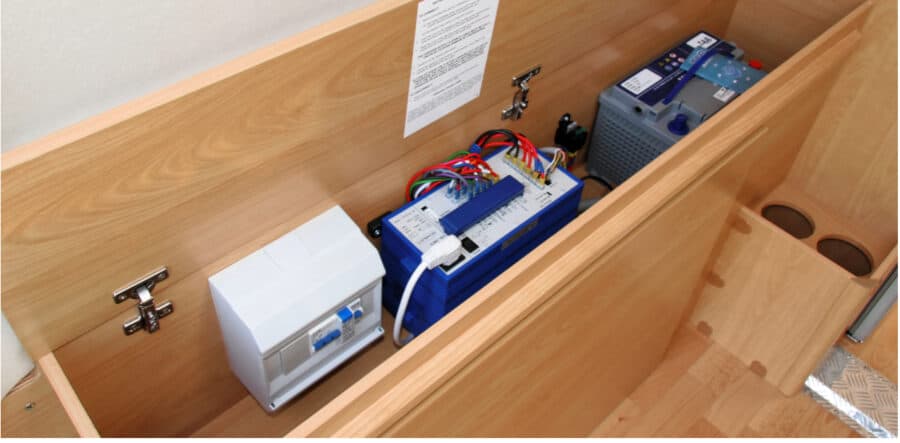 Interior RV panel with RV batteries and electrical components