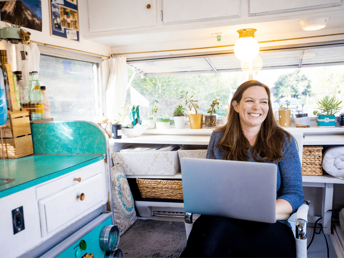  A woman sitting in a camper with a laptop on her lap
