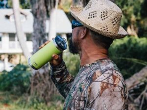 man in camouflage drinking from a Yeti insulated bottle