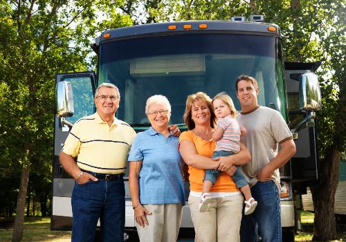 Family of 5 standing in front of a Class A motorhome