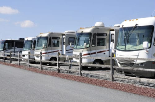 Class A motorhomes parked behind a picket fence