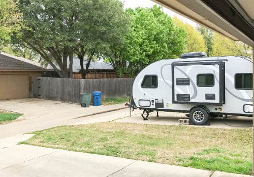 Camper parked in backyard on a driveway