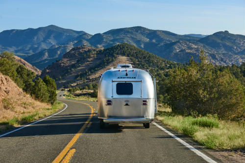 Airstream travel trailer on a windy, mountainous road