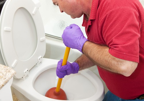 Man using the plunger in the the toilet