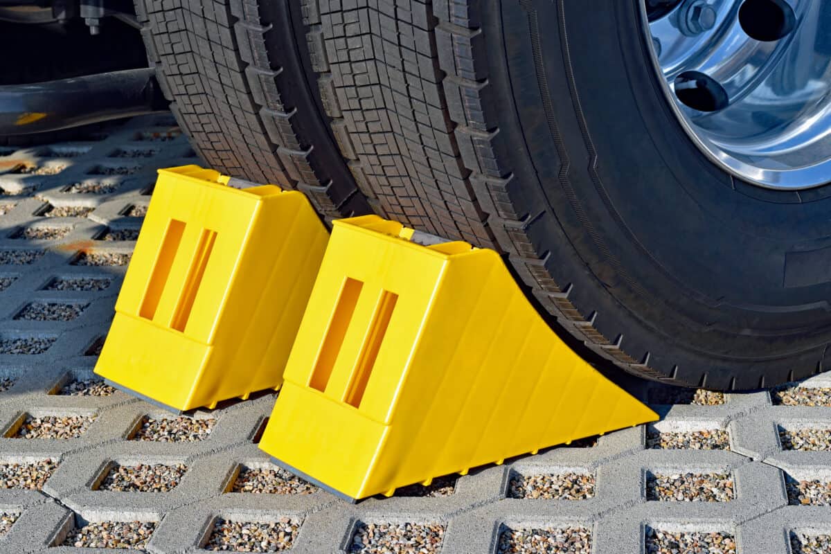 Yellow chocks at the wheel of a parked truck helps with RV leveling
