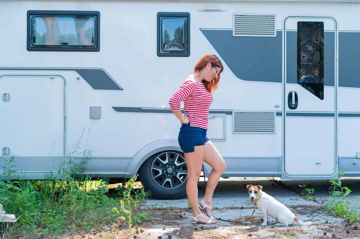 Girl trains dog in front of an RV