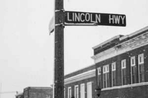 A black and white photograph of the Lincoln Highway sign
