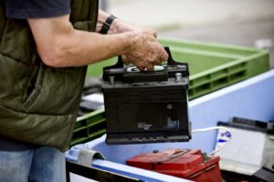 A senior man recycling an AGM battery