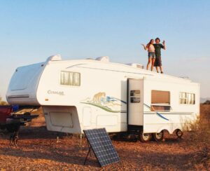 A couple standing on top of their fifth wheel RV