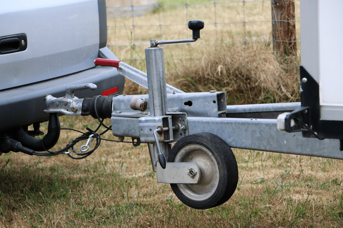 The coupler of a trailer attached to the ball hitch on a pickup truck