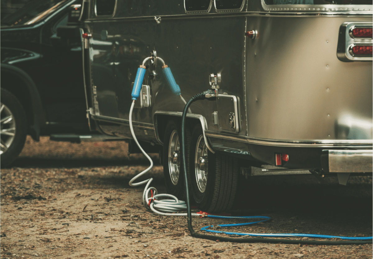 A travel trailer plugged into shore power using an extension cord